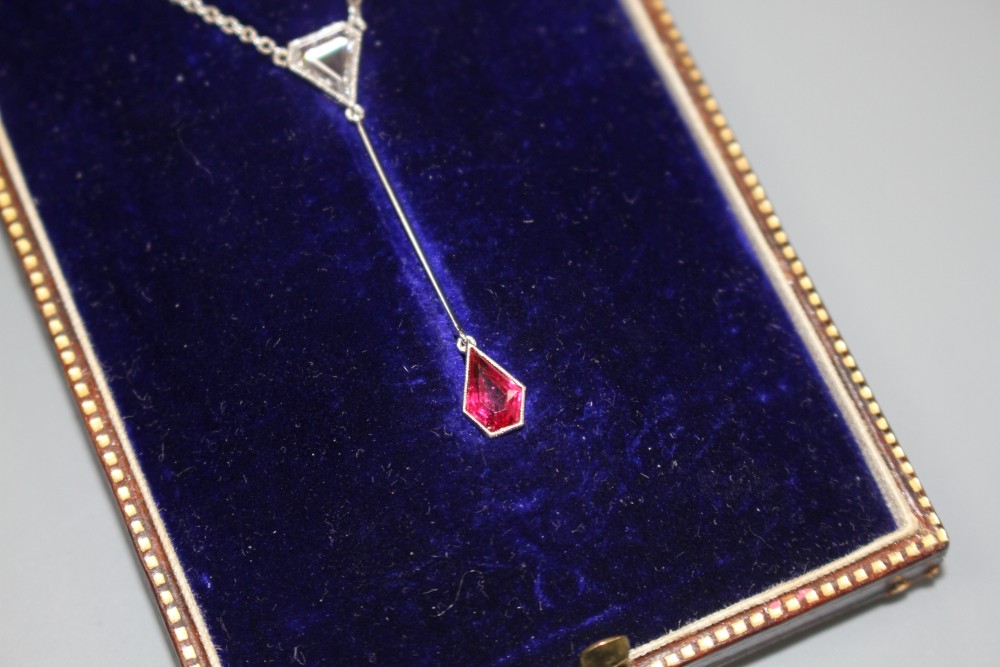 An Art Deco style white metal, ruby and diamond set drop pendant necklace, pendant section 40mm, gross weight 3.9 grams.